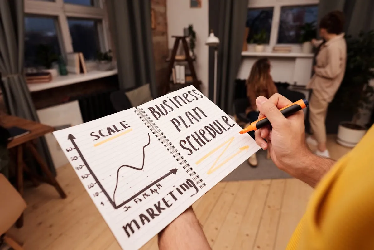 Empresário com caderno de planejamento e gráficos, organizando metas do negócio