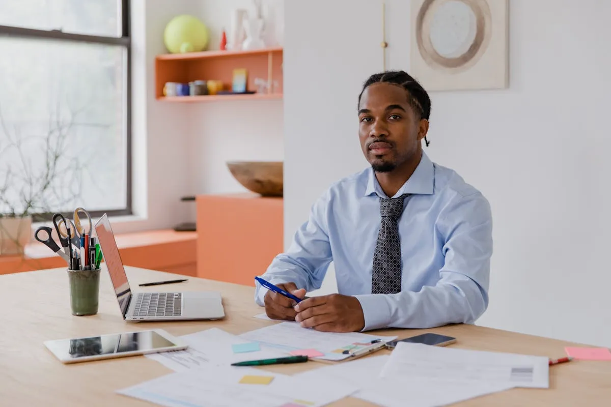 Empresário com expressão relaxada trabalhando com laptop em escritório organizado