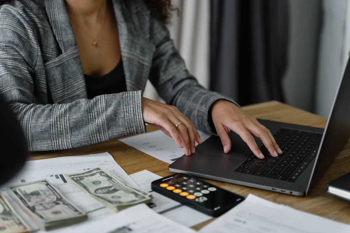 Empresário fazendo contas com calculadora e sorrindo, ambiente de trabalho positivo