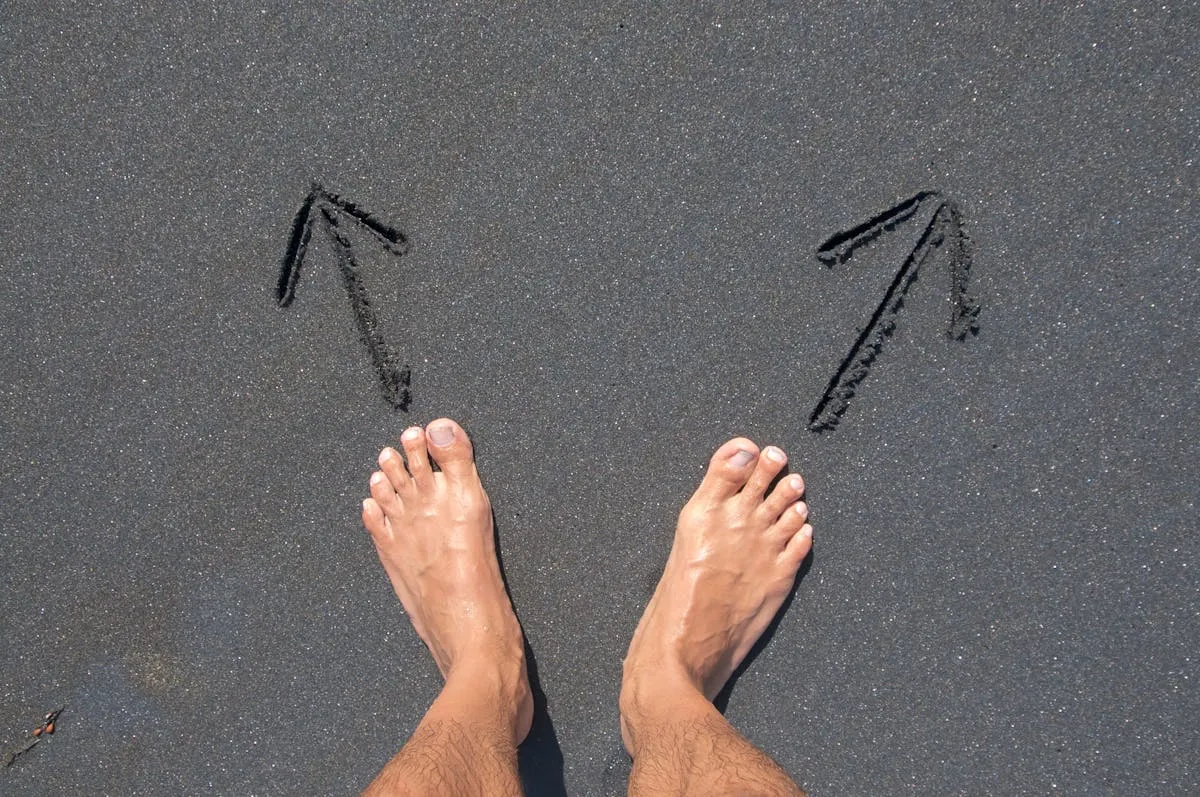 Duas mãos em encruzilhada, uma segurando notebook e outra segurando chave, simbolizando escolha de caminho