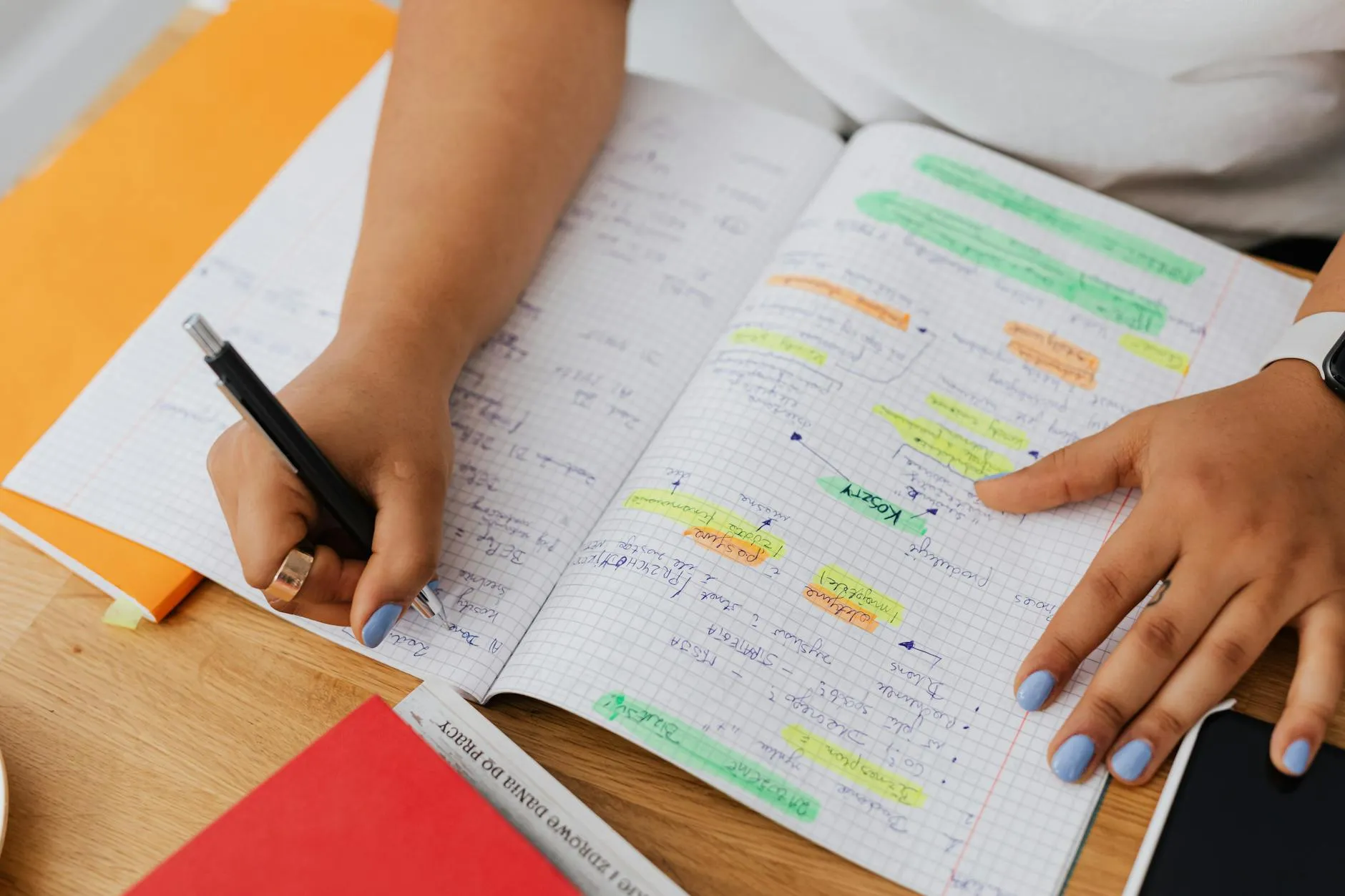 Empresário fazendo anotações em caderno antes de abrir o computador