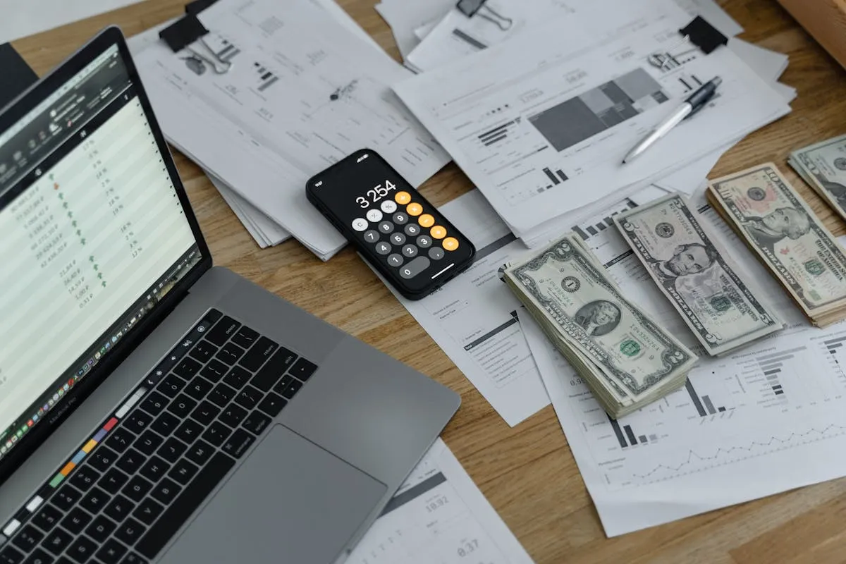Empresário calculando custos com calculadora e papéis na mesa de trabalho