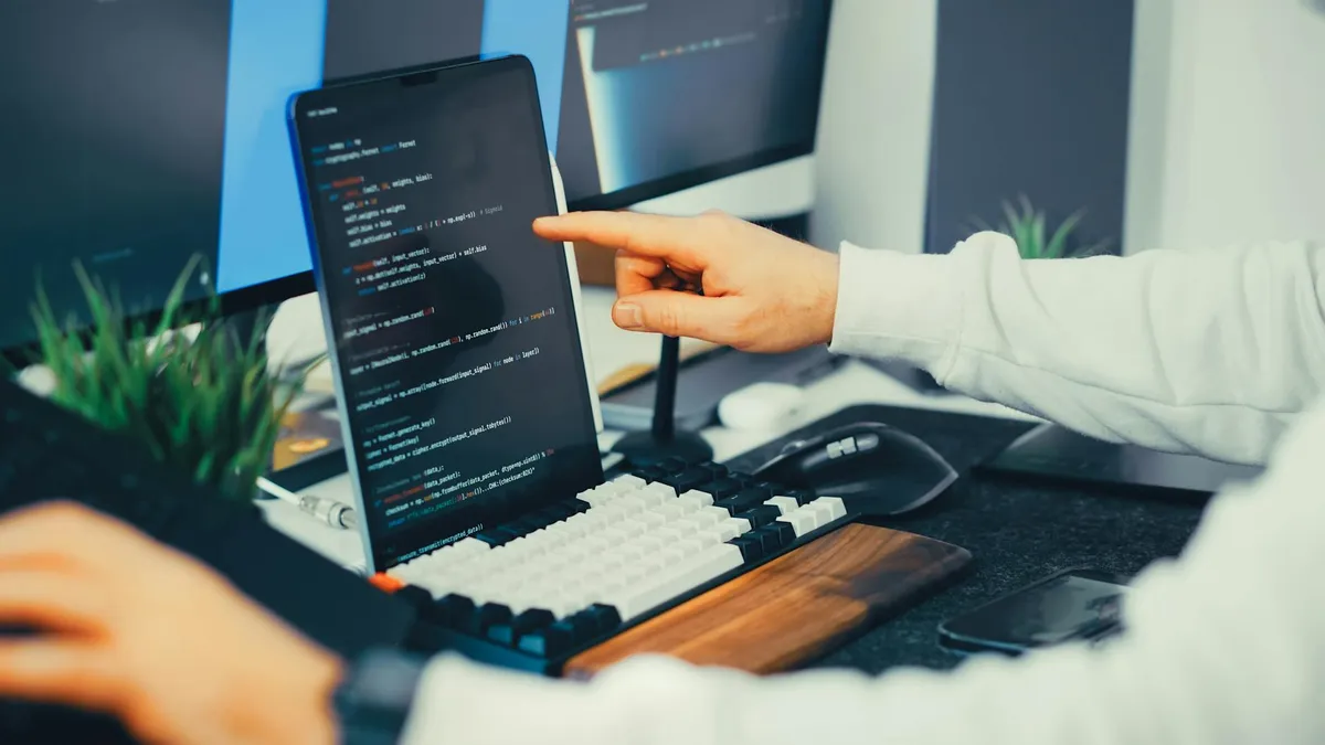 Empresário verificando assinaturas de software no computador em mesa de trabalho