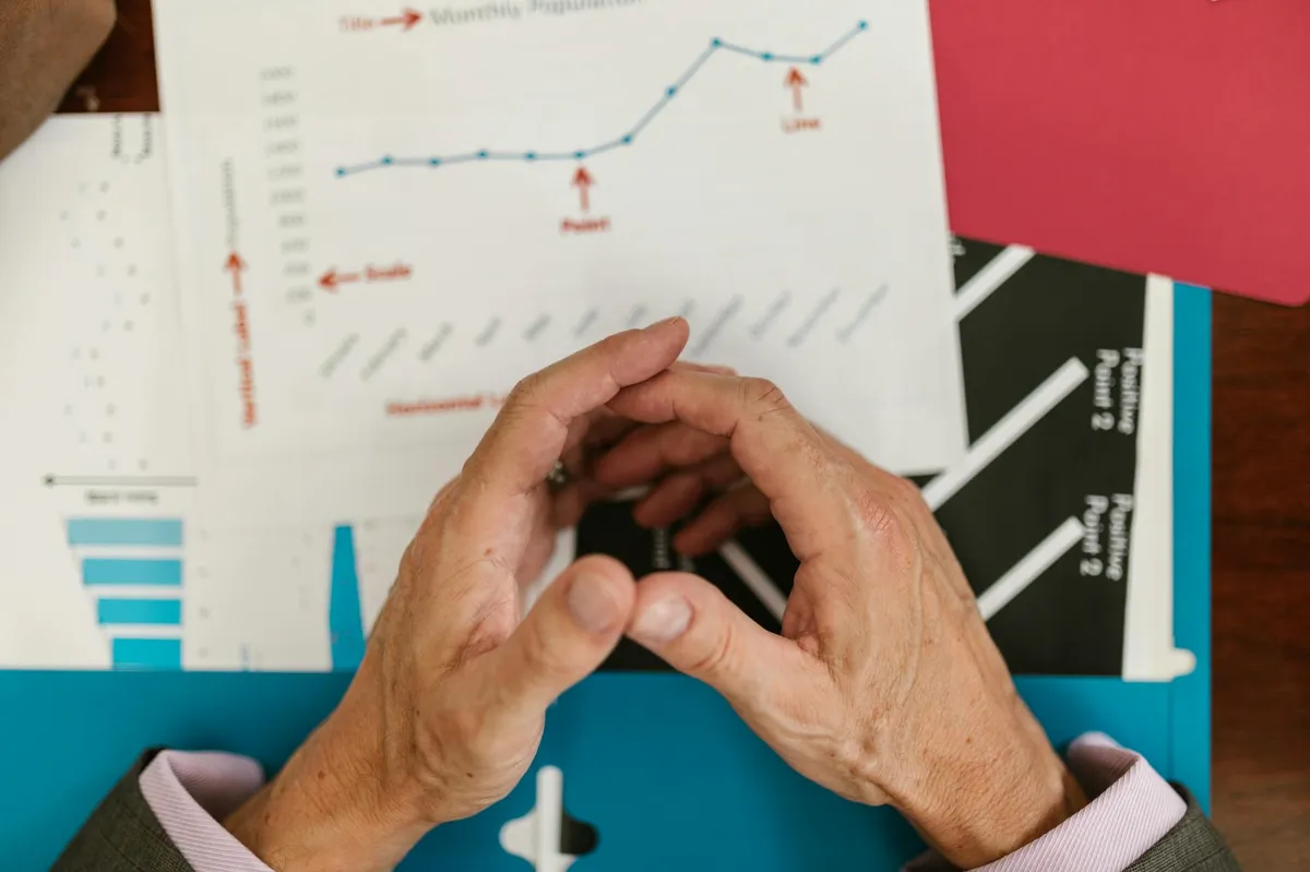 Empresário analisando relatório financeiro mensal em escritório com computador aberto